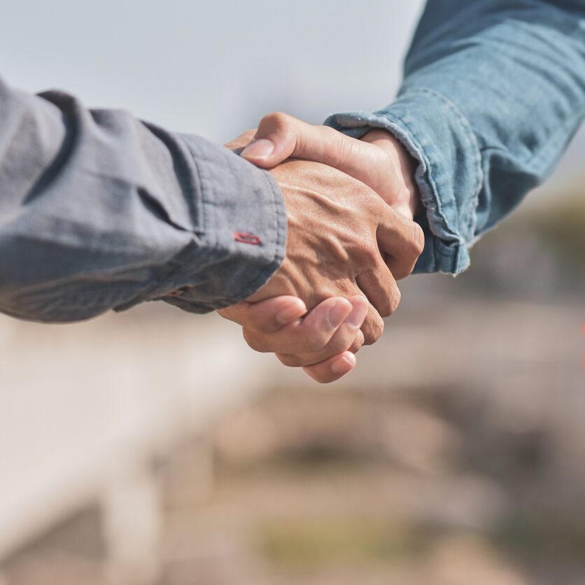 Close-Up Of Coworkers Shaking Hands At Construction Site